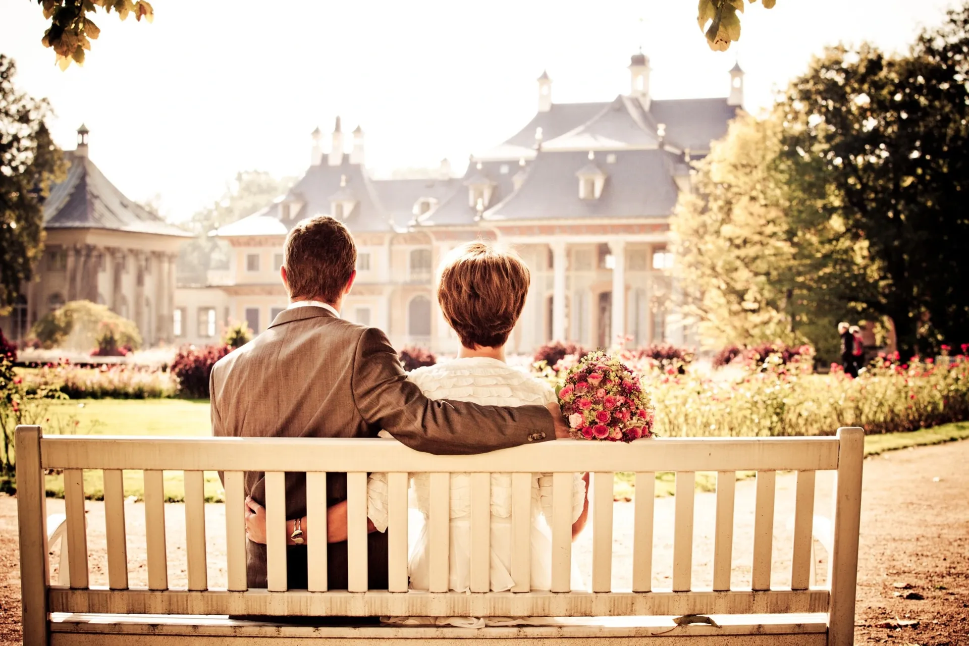 Paar sitzt auf einer Bank und schaut in die Ferne
